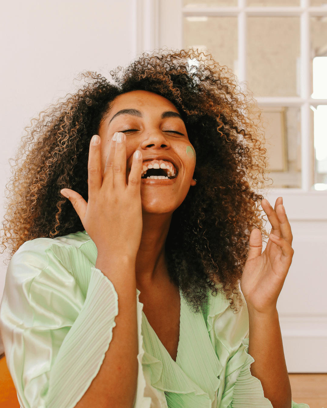 black woman touching her face and smiling